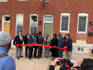 DHCD Assistant Secretary Greg Hare (second from left) joins Baltimore City officials and community partners for the ribbon cutting of the first four homes renovated through the Homeownership Works program.
