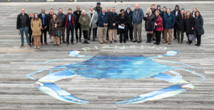 A group stands for a photo with a mural of a blue crab in Crisfield.