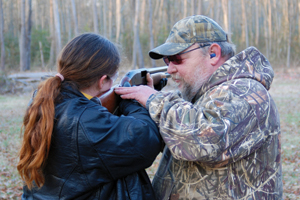 Photo of: man teaching woman how to shoot