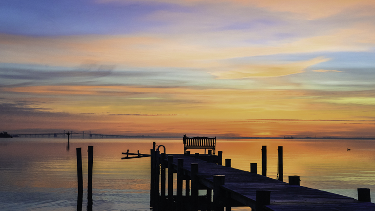 Photo of: Vibrant sunrise behind a dock