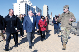 Photo of: Officials walking on beach