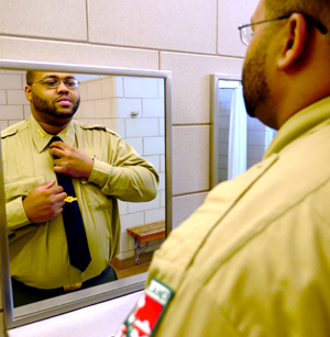 Photo of: Ranger adjusting his tie in the mirror
