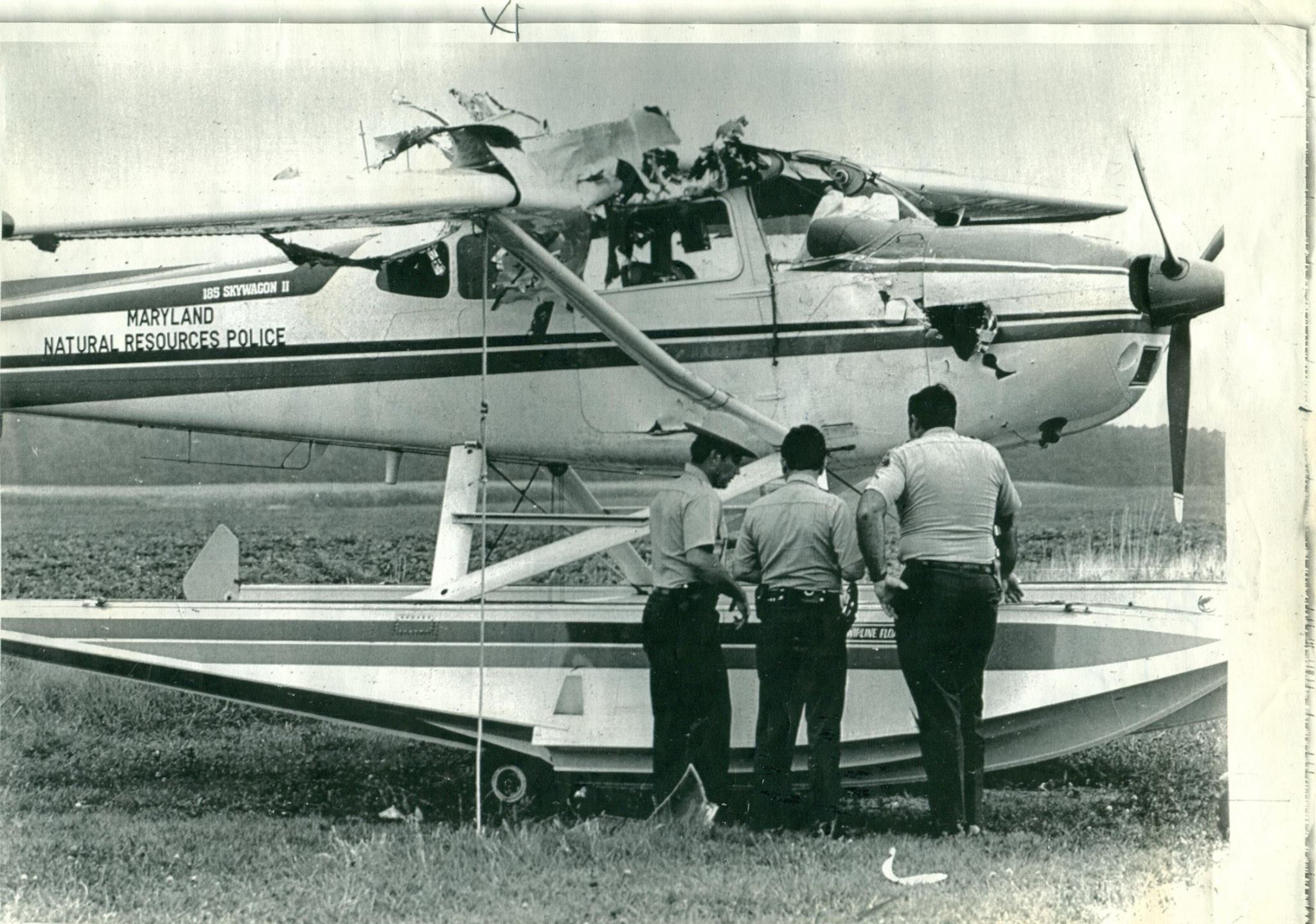 Photo of officers looking at damaged seaplane