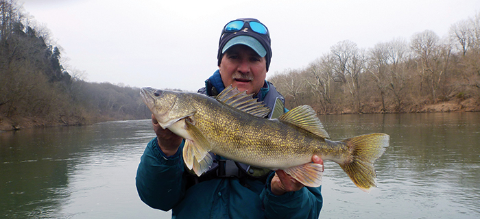 photo of man holding large yellowish fish