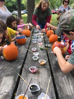 Photo of kids painting pumpkins