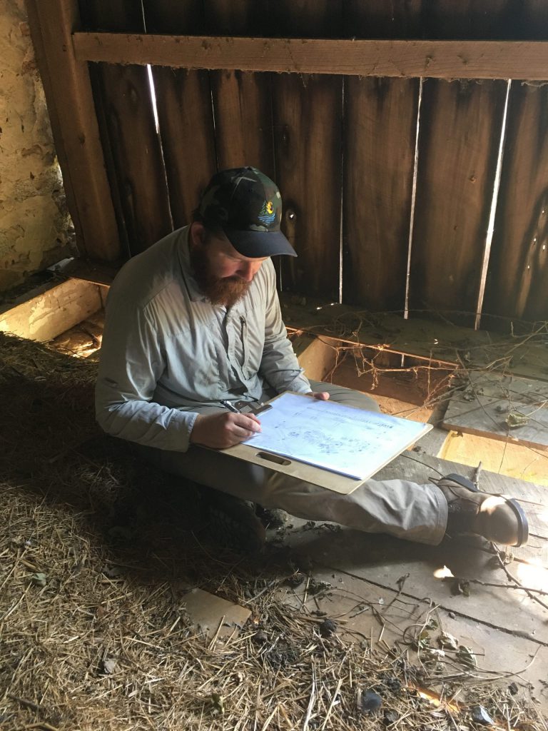 Photo of man sketching in barn