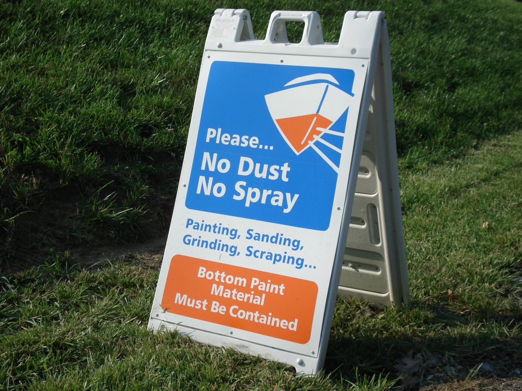 Sign about using groundcover to contain paint and dust