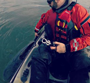 Photo of man releasing striped bass from kayak