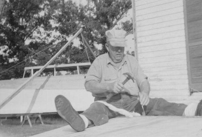 Photo of man working on building a boat