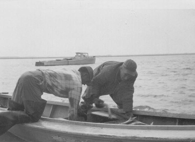 Photo of two men working on a boat