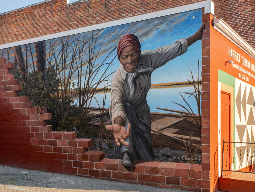 Photo of mural of Harriet Tubman reaching her hand to mural viewer