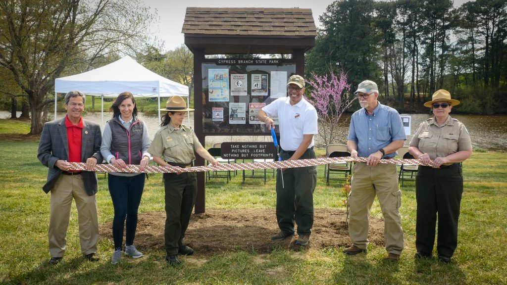 Photo of group of people cutting a ribbon at a state park