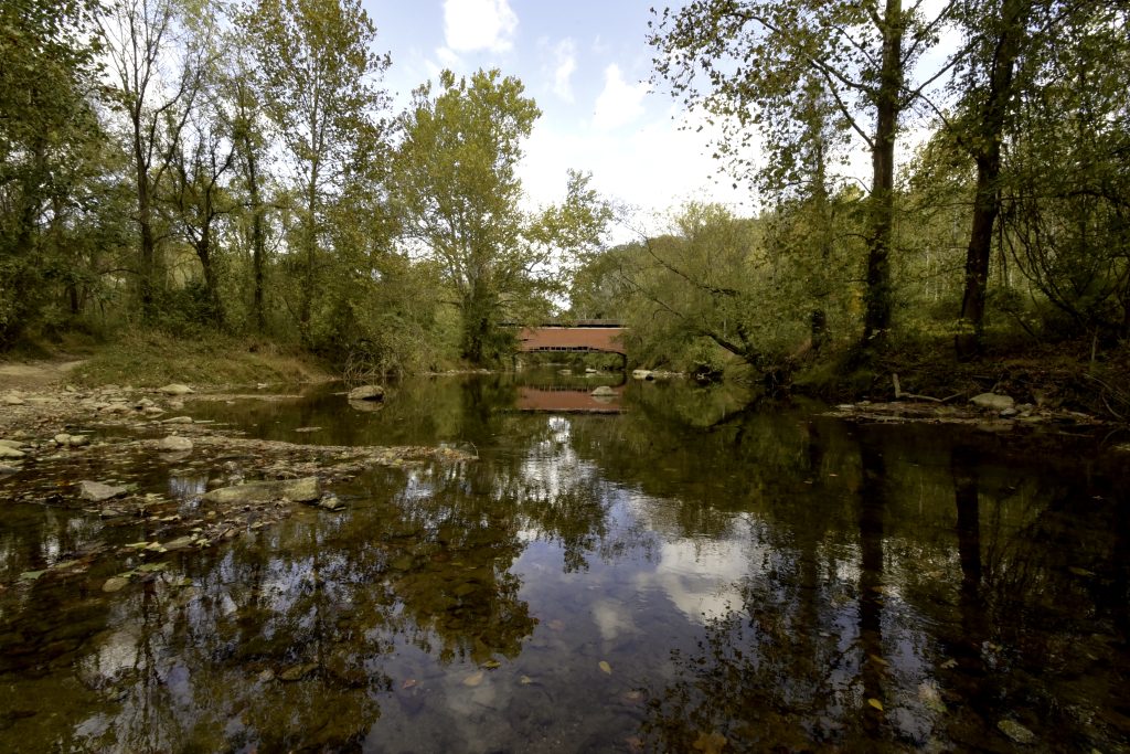 A bridge is reflected on the surface of a stream