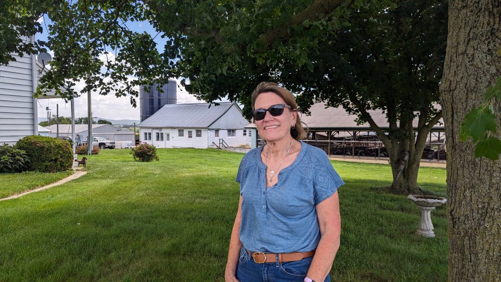 A woman poses near a dairy