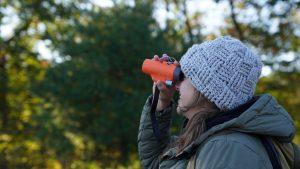 A person looks through a monocular.