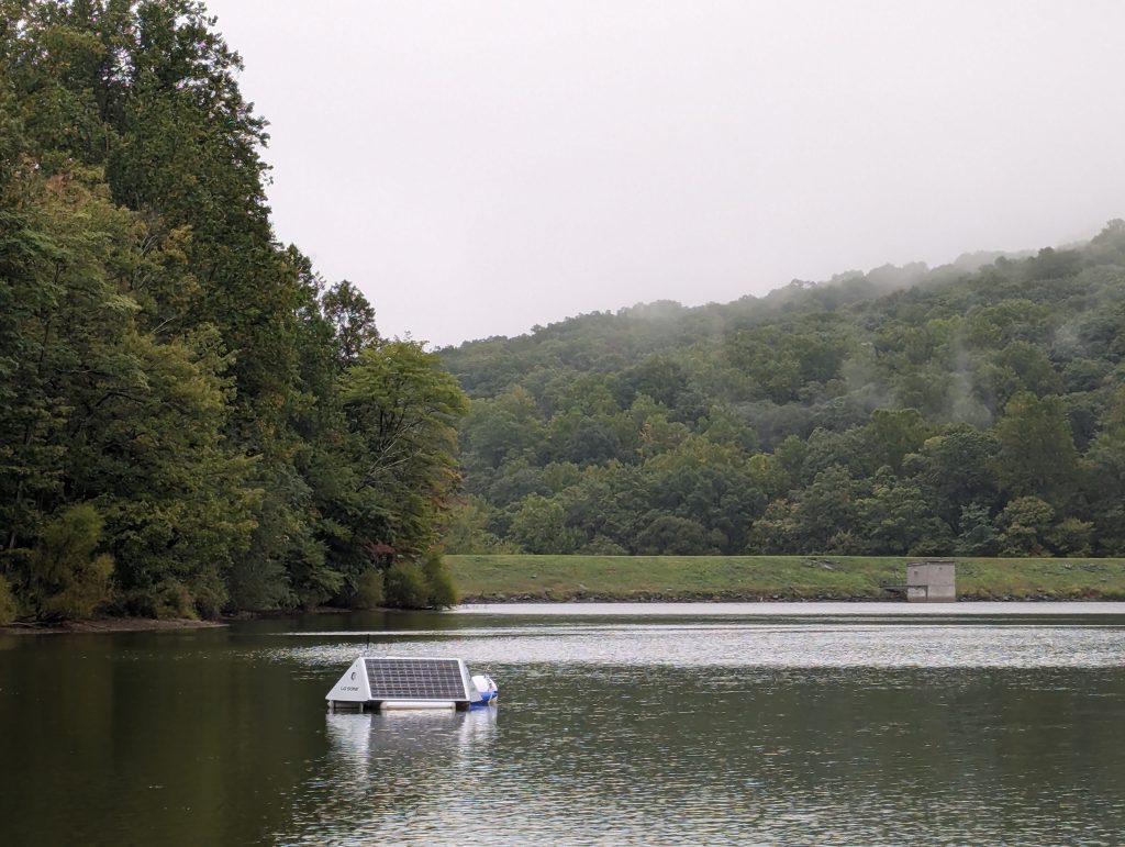 A buoy with a solar panel floats on a lake.