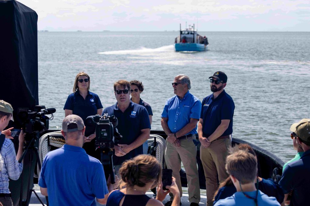 Officials on a boat for an oyster restoration event