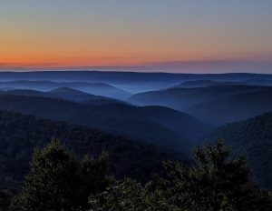 Mountain range during sunrise with fog in the valleys