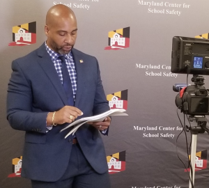 Dr. Tarik Harris speaking on camera in front of a MCSS backdrop.