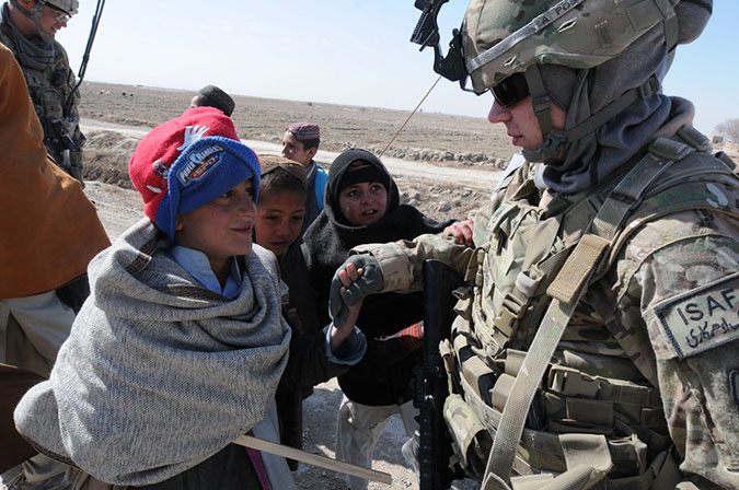 U.S. Army Staff Sgt. Nikita Zarelli, a member of the Female Engagement Team for C Troop, 5th Squadron, 1st Cavalry Regiment, 1st Stryker Brigade Combat Team, 25th Infantry Division, talks with a group of local Afghan children on their way to school in the Dand district, Kandahar province, Afghanistan, Feb. 9.