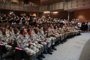 People sitting in an auditorium for a graduation ceremony.