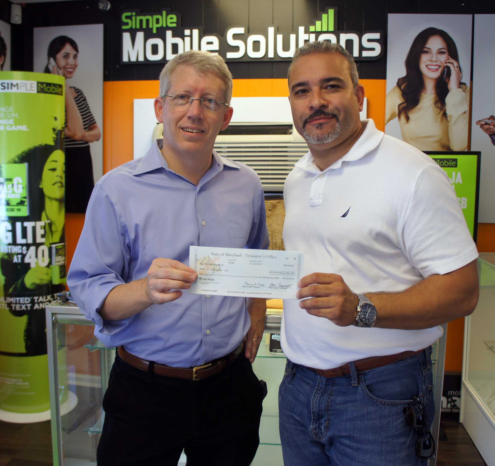 DHCD's John Maneval presents check to business owner Juan C. Nunez