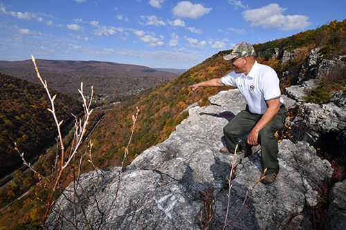 Photo of Lieutenant Governor Rutherford pointing at the view of a mountainside