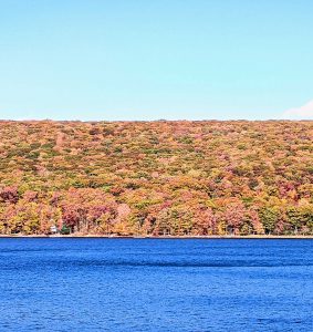 Forest of fall colors behind a blue Deep Creek Lake