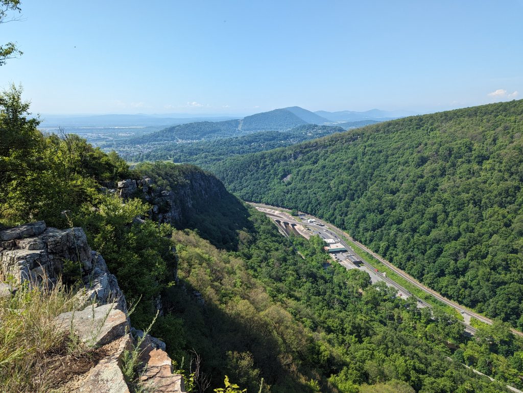 A view from a high vantage point showing a valley and mountains.